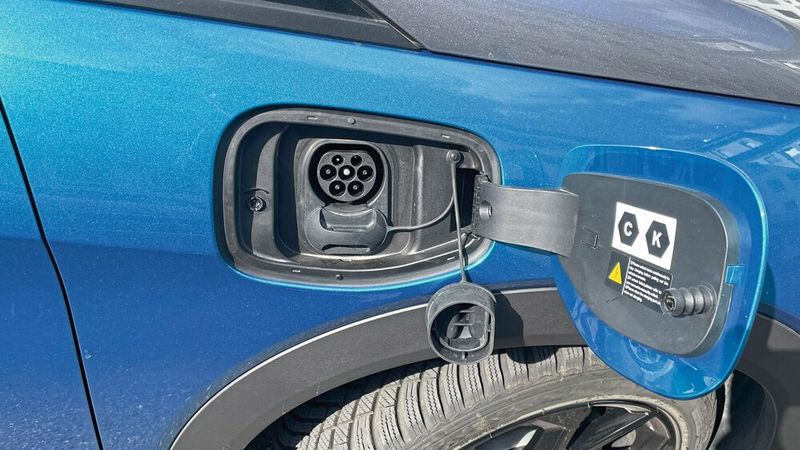 5. Ladestecker: Auf der Rückfahrt wiederholte sich das Verbrauchsszenario - vor allem aber blieb die Ladeklappe unbeabsichtigt die ganze Fahrt über aufgeklappt, inklusive der offenen Verschlussklappen am Stecker. Es piepste zwar regelmäßig wegen irgendwelcher detektierten StVZO-Übertretungen, doch eine Warnung für den offenen Deckel ist scheinbar nicht vorgesehen. (Bild: Grimm – VCG)