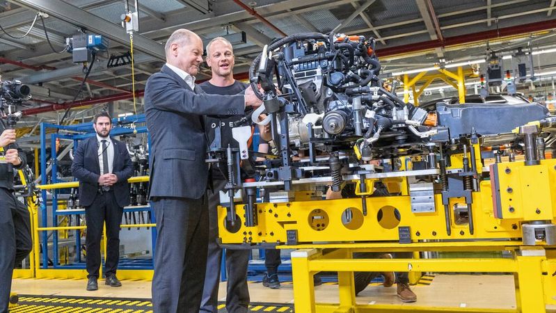 Kanzler am Band: Olaf Scholz montiert unter Anleitung ein Hochvoltkabel.(Bild:  Opel)