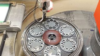 Einzeln und orientiert legt der Roboter hauptzeitparallel Werkstücke in die Läuferscheiben der unteren Flachhonscheibe, die sich im Automationsbereich befindet.  (Stähli Läpp Technik AG)