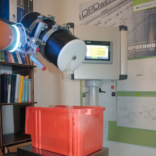 Der Roboterarm, der in die Automatisierungslösung integriert ist, nimmt anhand des ausgewählten Rezeptes genaue Dosierungen vor und füllt das Schüttgut in die entsprechende Wiegevorrichtung. Der Roboterarm, der in die Automatisierungslösung integriert ist, nimmt anhand des ausgewählten Rezeptes genaue Dosierungen vor und füllt das Schüttgut in die entsprechende Wiegevorrichtung.