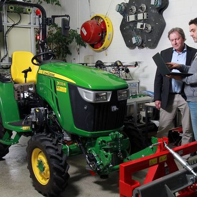 Zwei Experten vom Lehrstuhl für Robotersysteme der RPTU in Kaiserslautern stehen vor einem mit Sensoren, KI und Kameras ausgerüstetem Kleintraktor. Das Nutzfahrzeug kann so autonom agieren. Noch mehr davon kann man in Halle 2 auf der Hannover Messe erleben ... (Bild: RPTU / Th. Koziel)