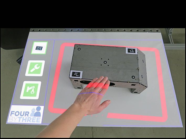 Ein optisches Arbeitsraum-Überwachungssystem auf Basis von Projektions- und Kameratechnik, ergänzt um Visualisierungs-, Werkerassistenz- und Interaktionsmodule. (Bild: Fraunhofer-IFF)