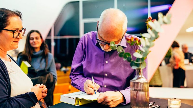 Die Gäste nutzten die Gelegenheit zum Austausch mit Peter Grandl und holten sich persönlich signierte Exemplare am Büchertisch. (Bild: Autohaus Stiglmayr)