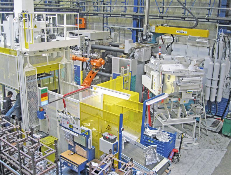 Vollautomatische Druckgiesszelle für Strukturguss im Werk Liberec. Die «Carat»-Druckgiessmaschine befindet sich hinten (in der Bildmitte), davor steht der Entnahmeroboter, rechts der automatische Dosierofen und links der Stanzautomat. Auf dem Förderband liegt ein gestanztes Gussteil. (DGS)