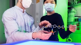 Philipp Buday (l.) und Chizuru Kasahara demonstrieren die lichtgetriebene Wasserstoffgewinnung. (Jens Meyer/ Universität Jena)