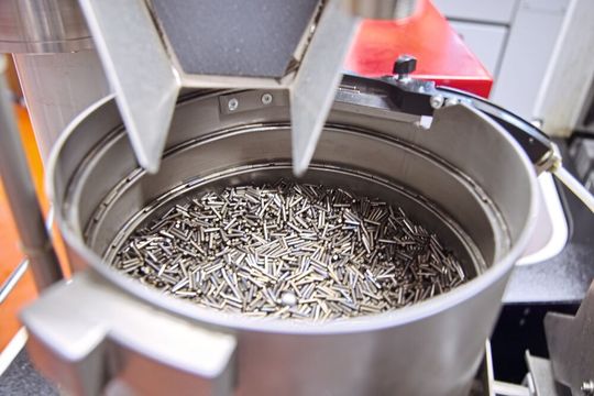 Hier ist die Zuführung der Rohteile gut zu erkennen, ebenso der zusätzliche Speicher, auf den Ferdi Saiti zeigt.(Bild:  Matthias Böhm)