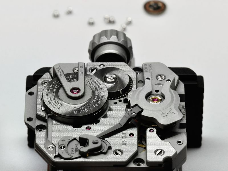 Rechts auf dem Urwerk ist die Unruh mit dem gekapselten optischen Sensor erkennbar, links unten die Regulierungsschraube für die Unruh. (Urwerk)
