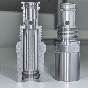 The component on the right and the cut-open version for examination on the left. The complete bore and the two cut-open bores on the left and right (in the left component) are clearly visible. The bore diameter is 5 mm, the inner diameter of the main bore at this point is 14 mm. The hole exit on the inside of the workpiece shown in the close-up (Fig. 3) was produced after approximately 4,000 drillings with the ExBurrDrill. There is no visible burr.(Image: Kempf GmbH)