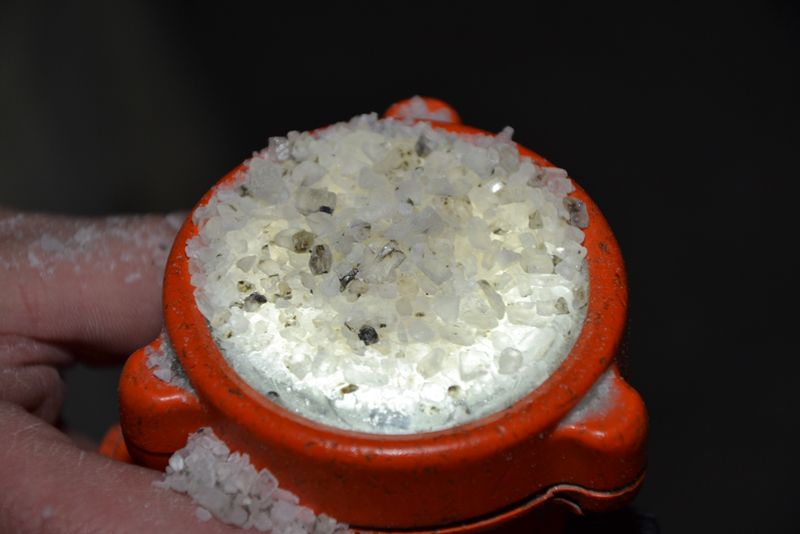 Im Lichtschein begutachtet der Bergmann die Kornverteilung und -zusammensetzung.  (PROCESS)