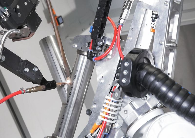 Koelleg Roboter im Einsatz:  Ein kurzes Aufblitzen, eine flinke Drehung des Roboterarms und schon ist ein neues Abzweigstück fertig.
 (Fotoatelier Bernhard e.K./HS Umformtechnik)