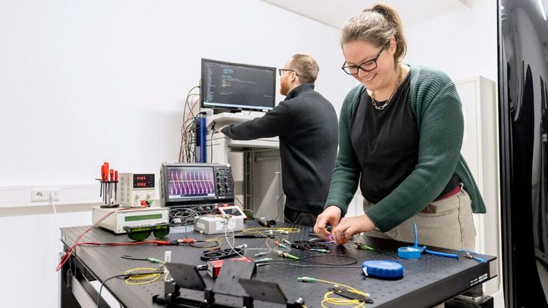 Das QKD-Labor der TÜV NORD GROUP am Standort Essen ist eines der ersten seiner Art in Europa. Sven Bettendorf, Projektleiter des QKD-Labors, und Natalie Jung, Evaluatorin mit Schwerpunkt QKD, bereiten einen Versuchsaufbau vor. (Bild:  TÜVIT)