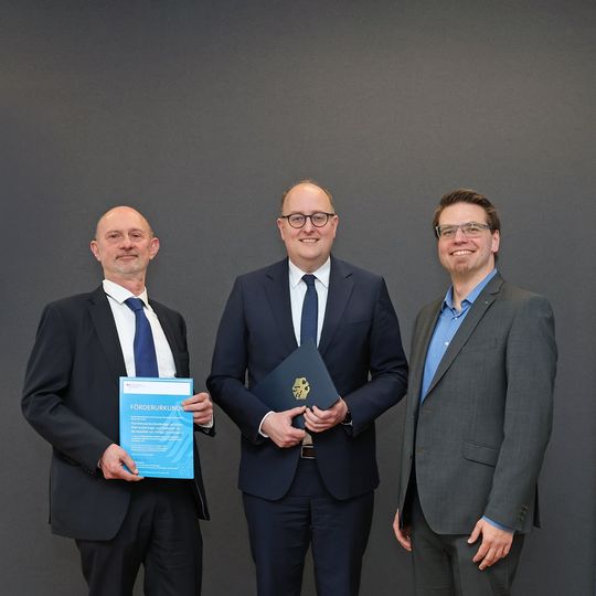 Dr. Gunther Kolb, Geschäftsbereichsleiter Dezentrale und Mobile Wasserstofftechnik am Fraunhofer IMM (li.), Parlamentarischer Staatssekretär Matthias Hauer (BMFTR) und Andreas Vogelpoth, Projektleiter InnoWaerm am Fraunhofer ILT.(Bild:  Fraunhofer ILT)