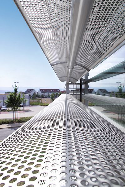 Als verstellbares Sonnenschutzsegel werden Aluminiumlochbleche an Außenfassaden von Bürogebäuden eingesetzt. (Dillinger Fabrik gelochter Bleche)