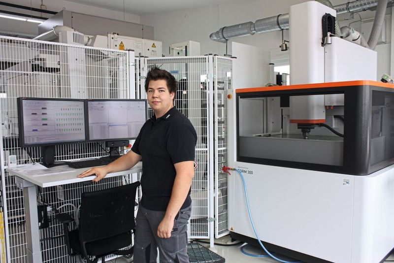 Tim Roolf von Föhl vor dem Workshop-Manager des Form Werks. Rechts ist die Senkerodiermaschine AgieCharmilles Form 300 zu sehen. (GF Machining Solutions)