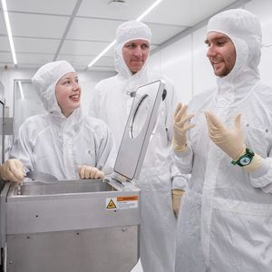 Lauren Riddiford, Aleš Hrabec et Jeffrey Brock (de gauche à droite) dans la salle blanche du Park Innovaare, juste à côté du PSI. C'est ici que sont créées les nouvelles structures magnétiques, qui sont modifiées de manière ciblée au laser.(Source :  Institut Paul Scherrer PSI / Mahir Dzambegovic)