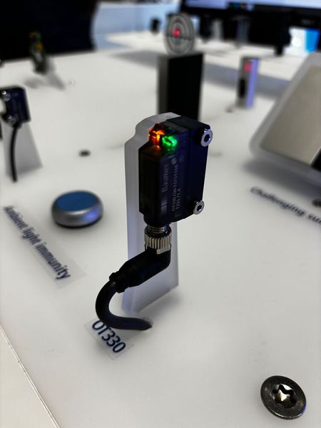 Baumer zeigt den OT330 Time of Flight Sensor: Der «OT330» ist ein photoelektrischer Time-of-Flight-Sensor mit Hintergrundausblendung für die zuverlässige Objekterkennung auch unter anspruchsvollen Bedingungen. Dank gepulstem Infrarot-Laser (Laserklasse 1) erreicht der Sensor eine Reichweite von bis zu 2,5 m und überzeugt durch hohe Unempfindlichkeit gegenüber Umgebungslicht sowie zuverlässige Erkennung selbst bei herausfordernden Oberflächen unterschiedlicher Farbe und Reflexion.  (Bild: Jeremy Streiff)