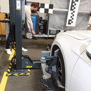 Wenn das Fahrzeug auf einer nicht ebenerdigen Fahrbühne steht, berücksichtigt dies das „Q.DAS“ automatisch. Die von den vorderen Radaufnehmern abgenommenen Messtafeln werden auf dem Messbalken des Kalibriergestells befestigt und korrespondieren dann über das Achsmesssystem „Q-Lign“ mit den hinteren. Dadurch lässt sich das Gestell exakt zur Geofahrachse ausrichten.(Bild:  »kfz-betrieb« / Dominsky)