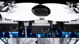 Beim Supragripper schweben zwei Greifer mit je drei Fingern frei über zwei halbmondförmigen Platten. (Festo)