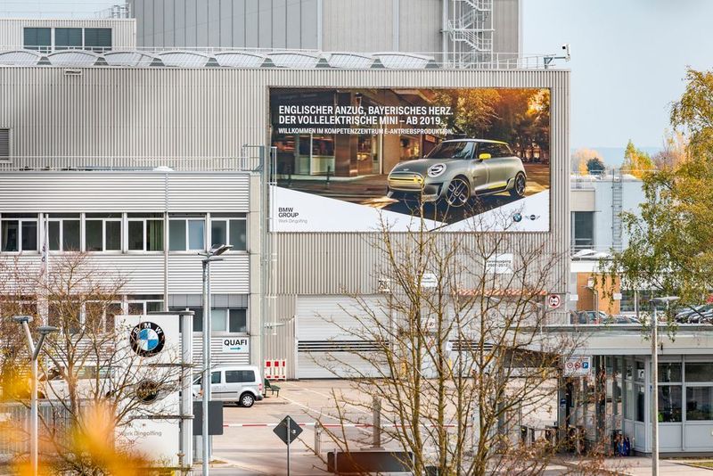 Großplakat an der Fassade des Werks „02.20“, das nun die Bezeichnung „Kompetenzzentrum E-Antriebsproduktion“ trägt. (BMW)