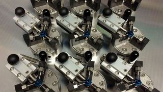 Das Bild zeigt Center-Fix-60-Systeme auf einer Zeiss-Wechselpalette, die auf einer Messanlage eingesetzt werden. Die Aufgabe besteht darin, ein Werkstück mit einer Aussparung wiederholgenau zu positionieren und leicht zu klemmen, damit der Messtaster die Werkstücke anschließend abfahren kann. Die Orientierung der Werkstückaussparung erfolgt über das an dieser Stelle optional installierte Linearsystem mit beweglicher Spitze. (Bild: Fischer TechServ)