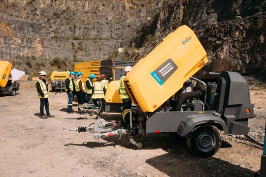 (Längst gehören elektrisch angetriebene, fahrbare Kompressoren wie hier im Bild zum Programm von Atlas Copco. Der Hersteller zeigte im Steinbruch Oetelshofen, wie sich Energiespeicher zum Beispiel mit Elektrokompressoren und Solarlichtmasten im Rahmen eines intelligenten Energiemanagements sinnvoll kombinieren lassen. (Bild: Atlas Copco))