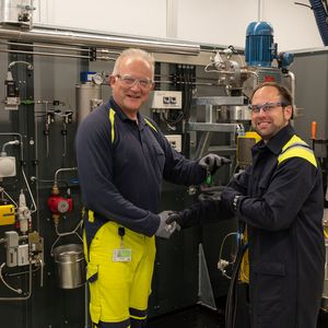 Projektleiter Martin Schneider (l.) übergibt den Schlüssel an Mark Seper, der als Leiter der Verfahrenstechnik viele Versuche auf der nagelneuen Anlage fahren und das Wissen um den komplexen Stoff Bitumen erweitern wird.(Bild:  Pörner)
