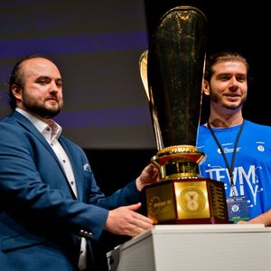 Der Captain des italienischen Teams (r.), das die ECSC 2025 in Warschau gewonnen hat, und Reich brachten zur Eröffnung der Challenge 2026 den Pokal auf die Bühne.(Bild:  Bochum Wirtschaftsentwicklung | Donna & der Blitz)