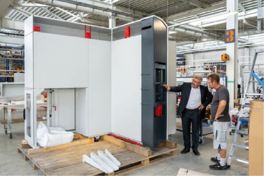 (Schinko-Geschäftsführer, Gerhard Lengauer (Mitte), an einem großen Maschinengehäuse im Gespräch mit einem Mitarbeiter. Bild: Schinko)