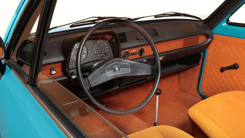 Ja, so übersichtlicht und luftig konstruierte man vor 40, 50 Jahren Fahrzeuginnenräume. Es war (fast) alles da, was man brauchte. Sogar Holz, wenn auch nur als Dekor, damals der letzte Schrei, gab es. Den Lichtschalter links vom Lenkrad gab's bereits im Käfer (1303). (Bild: Volkswagen)