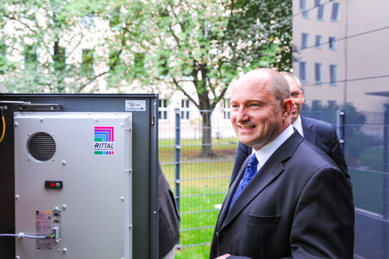 So sieht das Wohnen der Zukunft aus: Staatssekretär Rainer Bomba ist vom Projekt Effizienzhaus Plus in Berlin begeistert. Rittal lieferte für den Energiespeicher eine an das Gebäude farblich angepasste Outdoor-Lösung aus der CS Toptec-Reihe. (Rittal)