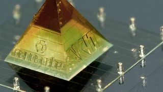 Auf den Seitenflächen dieser 3D-gedruckten Miniatur der Karlsruher Pyramide befinden sich die Logos von HeKKSaGOn, des KIT und Nanoscribe. Sie hat eine Gesamthöhe von nur 2 mm. (Nanoscribe)