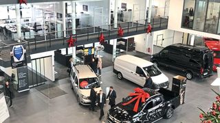Unten im Atrium befinden sich die zentrale Kundenannahme (li.) und der Showroom, darüber reihen sich die Büros mit bodentiefen Fenstern. (Faust)