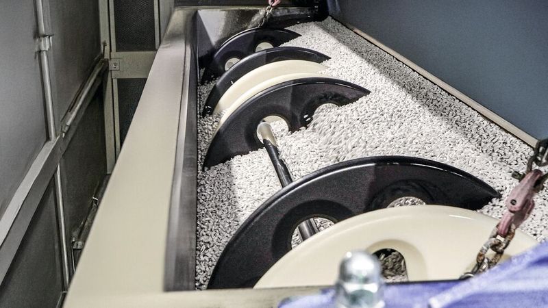 Nach dem Einlegen in Schlaufen kann sich die Bauteileaufnahme mit den Extruderschnecken frei in den Schleifkörpern bewegen und lässt sich wieder einfach und automatisiert herausnehmen.  (Bild: Rösler)