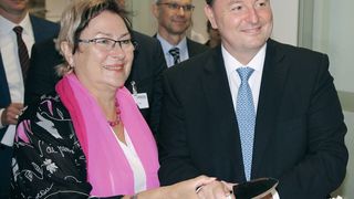 Petra Wust, Oberbürgermeisterin der Stadt Bitterfeld-Wolfen, schneidet mit Jean-Marc Vesselle, Leiter des Geschäftsbereichs LPT, die Geburtstags­torte an und gratuliert. (Ernhofer / PROCESS)