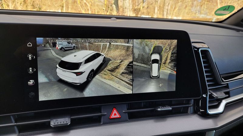 6. Der 360-Grad-Around-View-Monitor: Heutzutage parken Autos ja gern mal selbst ein. Beim Kia Sportage klappt das sogar von außen. Wer gern sitzen bleibt und selbst steuert, freut sich über den Around-View-Monitor, der den Sportage und seine Umgebung beim Rangieren nicht nur von oben zeigt, sondern gleichzeitig auch einen seitlichen Blickwinkel bietet. Das beeindruckt sogar wenig auto-affine Beifahrer. (Bild: Wehner/Vogel Communications Group)