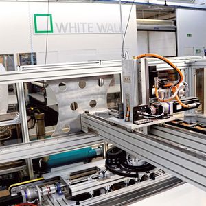 Das Portal-Drehkreuz entnimmt die Leiste aus der Schwenkkulisse und platziert sie auf dem Bildträger. (Bild:  SEW)