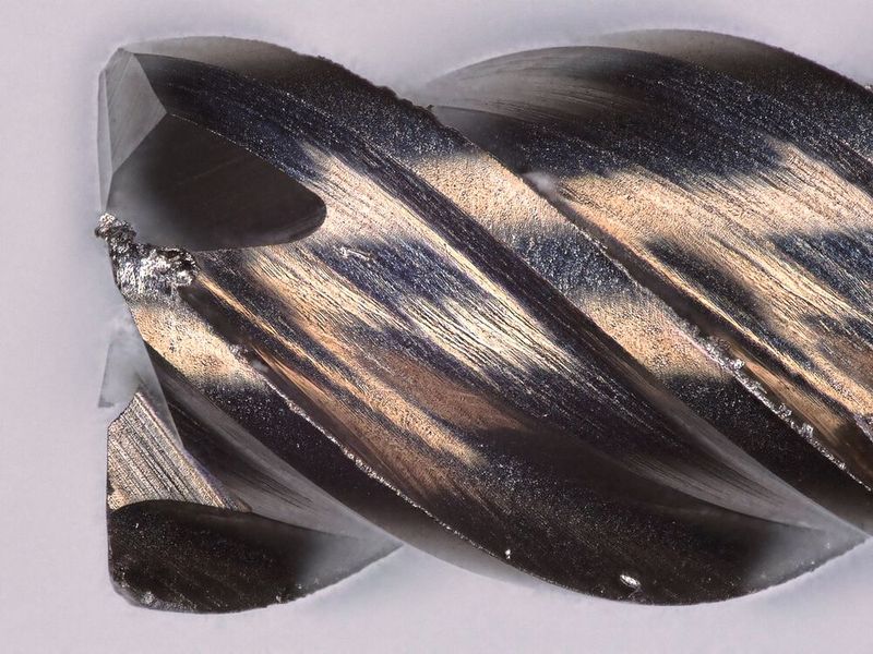 Dans la colonne de gauche, les outils non revêtus ayant réalisé 819 empreintes dans du titane de grade 2 sur un micro-centre d'usinage. À droite, les mêmes outils revêtus avec le nouveau revêtement MARC pour le micro-usinage du titane et sa couleur caractéristique. L'usure des outils est bien moindre et il n'y a quasiment plus de matière collée sur l'outil.  (Source : Louis Bélet)