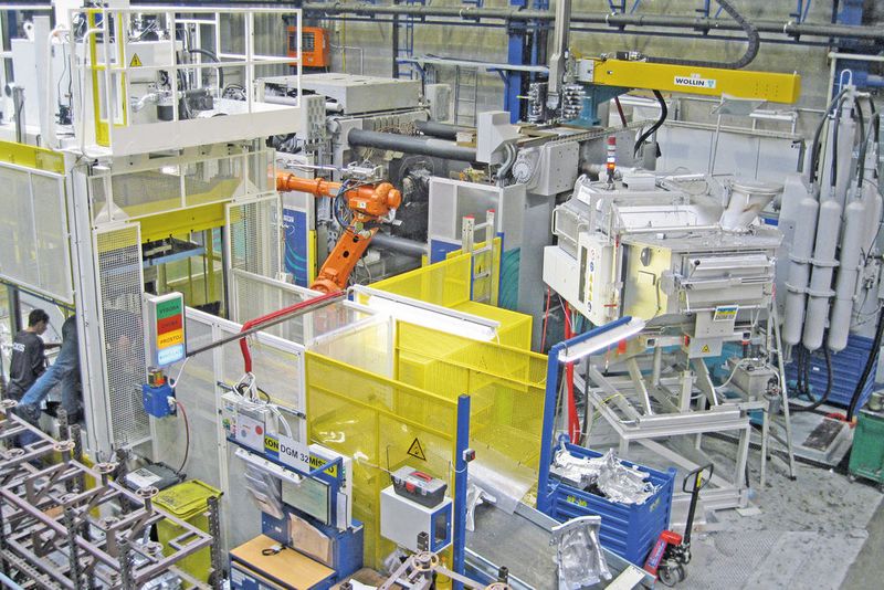 Vollautomatische Druckgiesszelle für Strukturguss im Werk Liberec. Die «Carat»-Druckgiessmaschine befindet sich hinten (in der Bildmitte), davor steht der Entnahmeroboter, rechts der automatische Dosierofen und links der Stanzautomat. Auf dem Förderband liegt ein gestanztes Gussteil. (DGS)