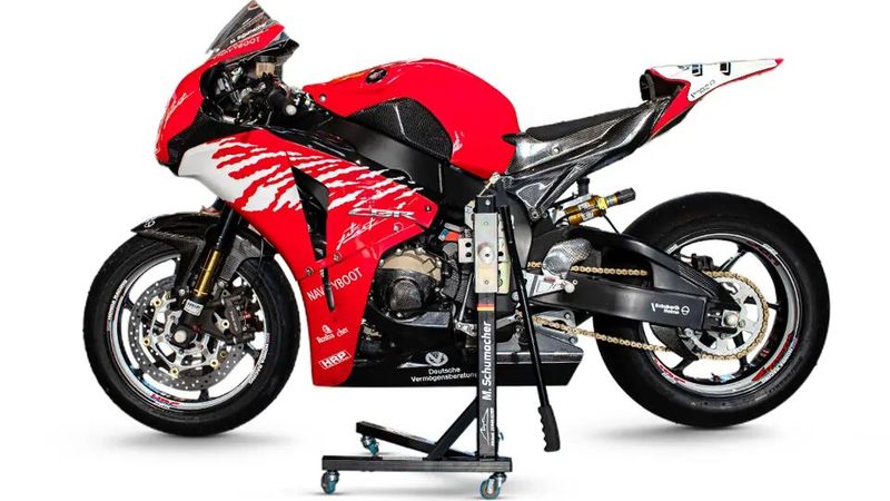 Einziges Fahrzeug der Auktion ist diese 2010er Honda CBR1000RR SC59 mit einem Schätzwert von 25.000 bis 35.000 Euro. Holzhauer Racing Performance (HRP) baute die von der Straße auf die Rennstrecke um, damit Michael Schumacher sie während Testtage nutzen konnte. Mit der Rennnummer „77“ gibt es mehrere Fotos in den Akten, die Schumacher auf dieser Honda zeigen. Dazu gibt es einen signierten Schuberth-Helm und ein signiertes Paar Motorradhandschuhe. HRP hat spezielle Komponenten wie eine Airbox, einen Ölkühler, einen Lenker, einen Schnellwechsler, eine Akrapovič Titan-Auspuffanlage und vieles mehr eingebaut. Das Motorrad wurde über einen längeren Zeitraum nicht gefahren und müsste daher vor dem Einsatz auf der Rennstrecke gewartet und überprüft werden. Der Kilometerzähler zeigt zum Zeitpunkt der Katalogisierung 3.752 Kilometer an. (Bild: RM Sotheby’s )
