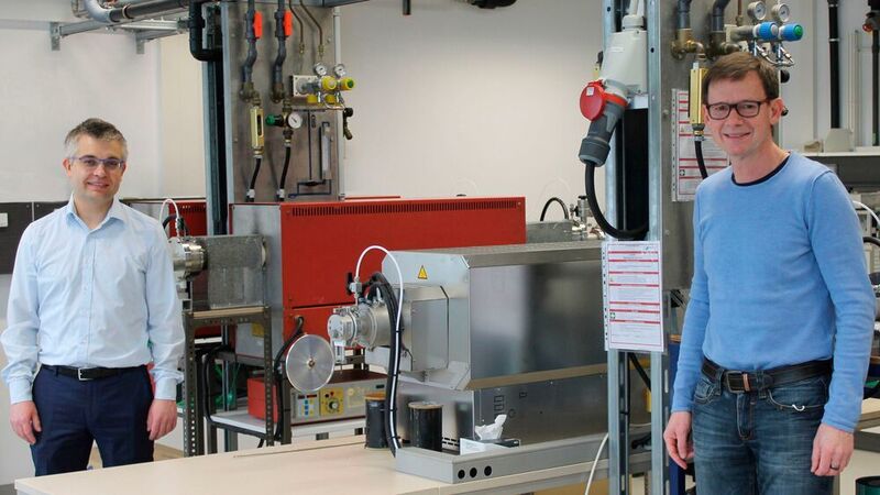 Prof. Dr.-Ing. Stefan Schafföner (li.) und PD Dr. Günter Motz (re.) vor dem Ofen für die Herstellung der Carbonfasern bei 1400 °C. (Christian Wißler/Universität Bayreuth)