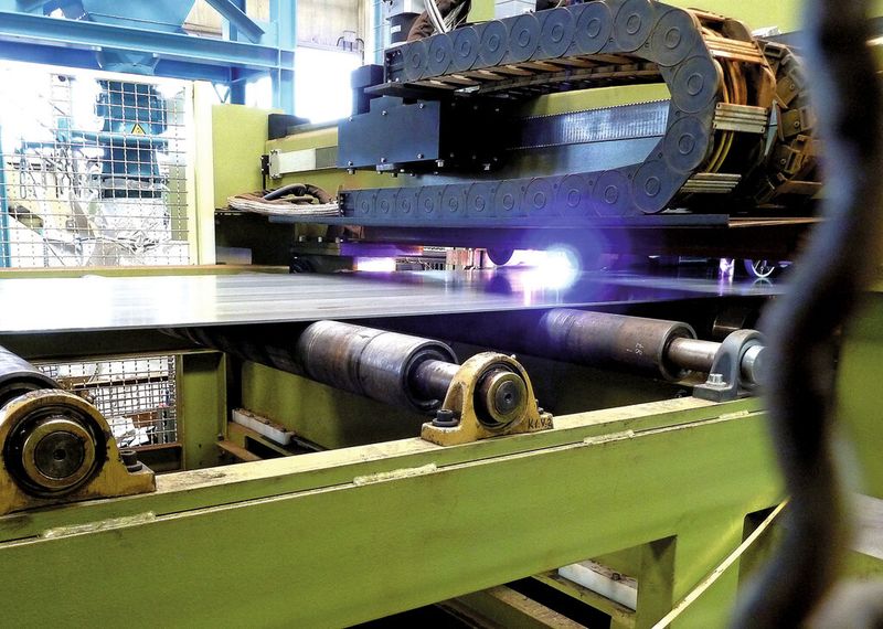 Nach dem Richten werden die Bleche mithilfe einer Plasmaschneidanlage vom Coil abgetrennt. Danach werden die Tafeln, die bis zu 12 m lang sein können, längsgeschnitten (gespalten). Aus einer Tafel entstehen so drei Platinen. (Bild: Kuhn)