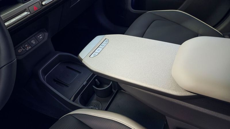 Diese Ablage in der Mittelarmlehne lässt sich nach vorn herausziehen, um beispielsweise den Laptop darauf abzulegen, während das Fahrzeug lädt. (Bild: Kia)