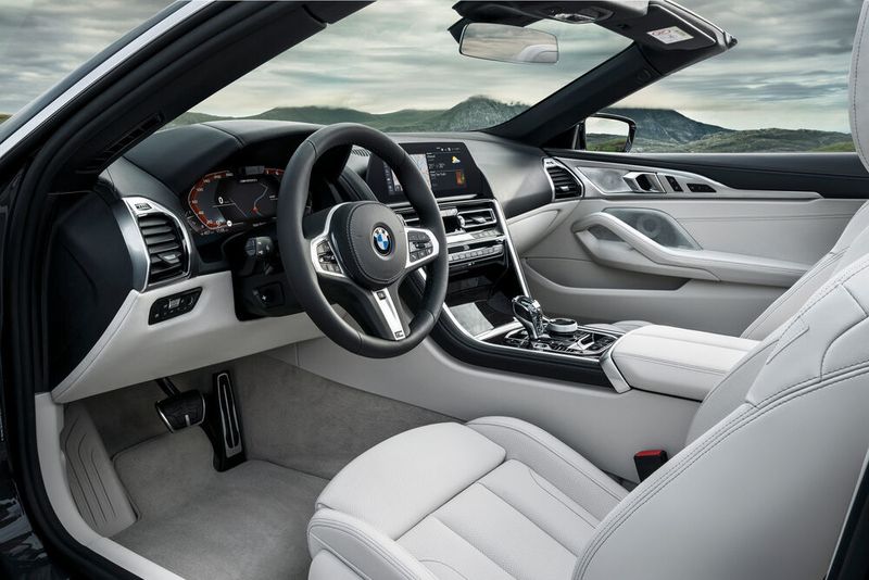 Fahrer und Beifahrer blicken auf eine Armaturentafel, die sehr eigenständig gestaltet ist und sich deutlich von der altmodischeren Formensprache der aktuellen Limousinen und SUV-Modelle der Marke abhebt. (Daniel Kraus/BMW)