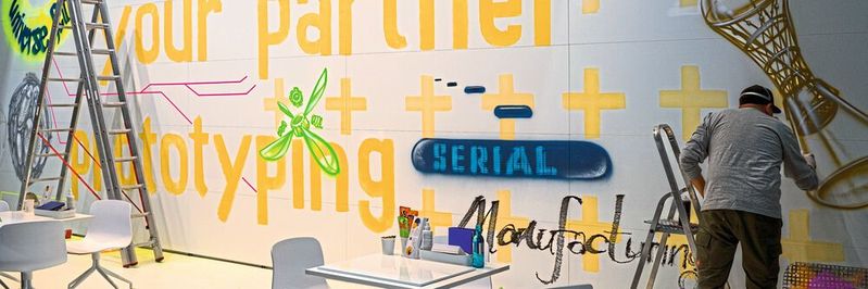 Formnext 2021. Der Auftragsfertiger Fit entschied sich dieses Jahr gegen Exponate. Dafür wurden täglich die wichtigsten Themen aus den Gesprächen an die Wand des Messestands gesprüht. (Bild:  S. Guggenberger / VCG)