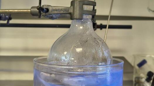 The chemical processes occurring when the light interacts with the plastic when it is dissolved causes the reaction to glow blue.(Source:  University of Bath)