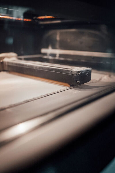 Maschine läuft: schichtweiser Auftrag des Sinterpulvers auf einer professionellen SLS-Anlage. (Daimler)