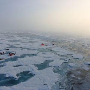 Abb. 2: Luftaufnahme arbeitender Polarforscher auf einer großen Eisscholle in der zentralen Arktis. Unter ihnen sind auch die Meereisphysiker, die ein Zelt errichtet haben, aus dem sie den Tauchroboter unter dem Eis steuern.