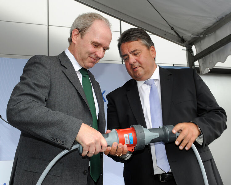 Merck-Chef Karl-Ludwig Kley (li.) und Bundewirtschaftsminister Sigmar Gabriel nehmen mit einem Stromkabel das neue Blockheizkraftwerk in Darmstadt in Betrieb. (Bild: Merck)
