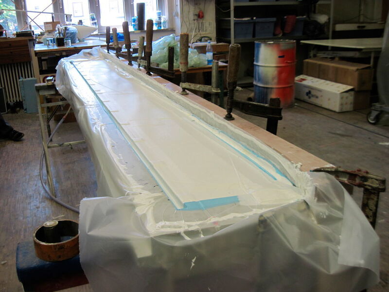 Während dem Aushärten des Harzes wird alles mit Vakuum verpresst. Dazu wird zunächst ein spezielles Abreißgewebe auf das fertige Laminat gelegt, welches sich auch nach dem aushärten abziehen lässt. Darauf folgt ein weiches Material, dass den Druck gleichmäßig verteilt und schließlich eine luftdichte Folie. (Akaflieg Karlsruhe)