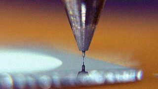 Mikroschleifstift mit Durchmesser von 30 µm und einer Länge von 100 µm beim Ankratzen von Silizium. Das Mikrowerkzeug kann auch Hartmetall bearbeiten.  Bild : FBK (Archiv: Vogel Business Media)
